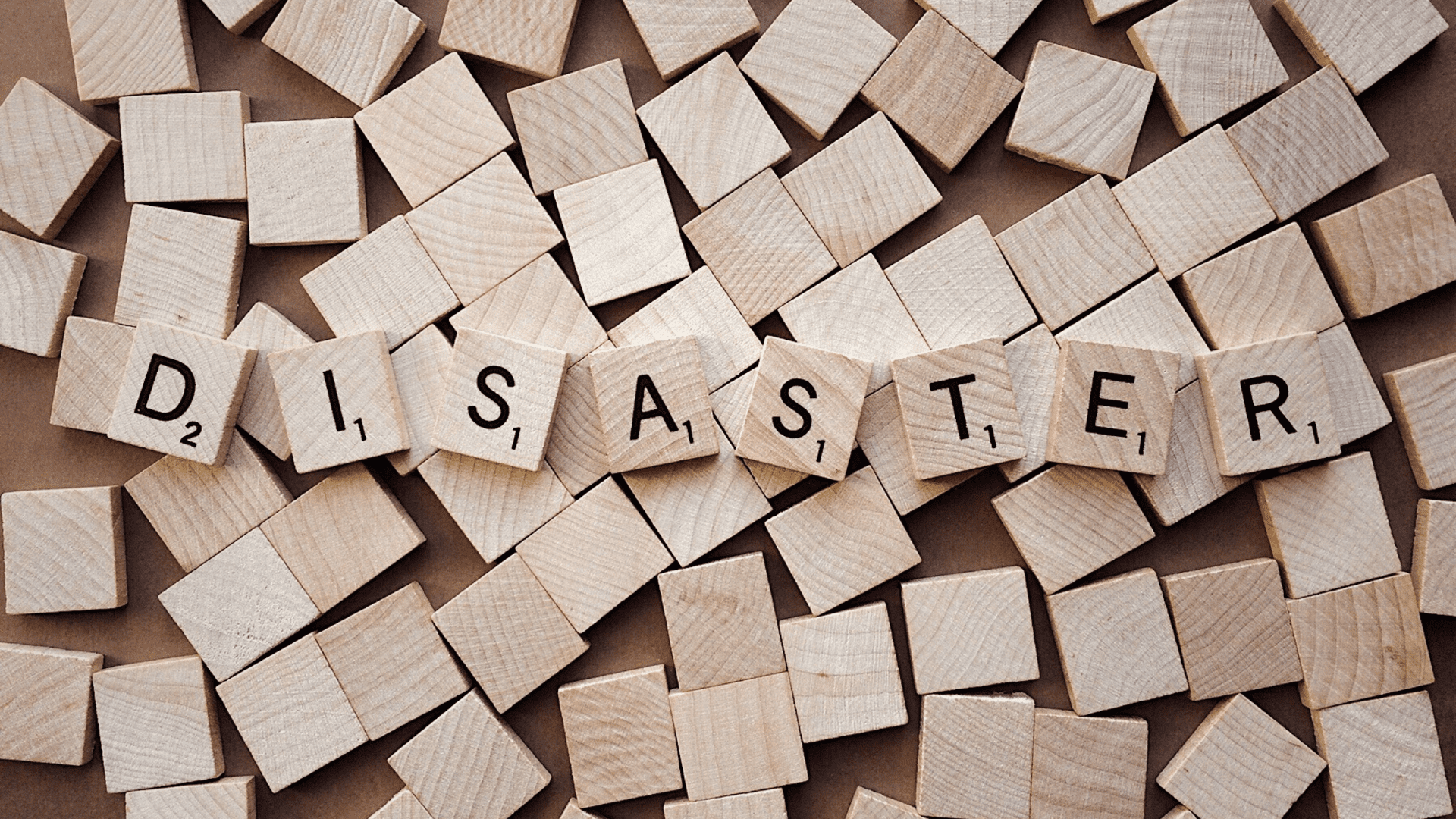 An image shows many wood cubes on the floor with the text disaster.
